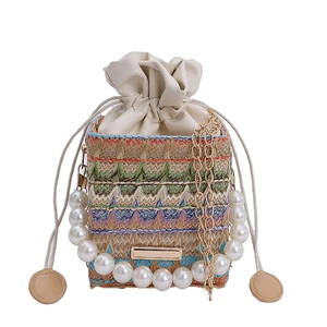 Ethnic woven crossbody bag with colorful wavy patterns and elegant pearl handle strap
