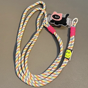 Close-up of colorful braided crossbody phone strap with a cute cartoon cat clip and smile tag
