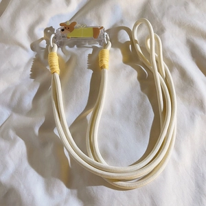 Detail of a thick cream braided phone strap with a cute cartoon puppy acrylic clip