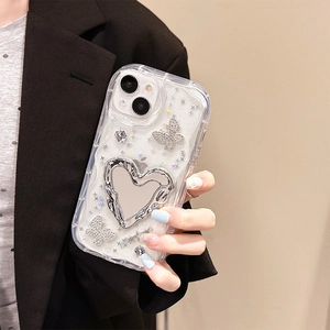 Detail of glitter iPhone case featuring silver butterfly rhinestones and heart-shaped mirror