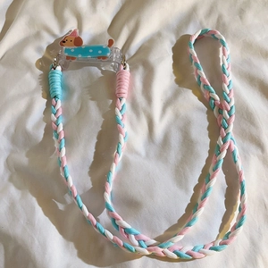 Detail of blue, pink, and white braided phone lanyard with cute cartoon puppy charm