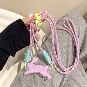 Detail of pink acrylic bunny charm with adjustable colorful woven phone lanyard strap