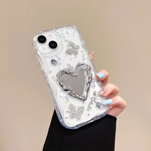 Detail of clear iPhone case with silver metal butterfly, glitter and heart mirror accents