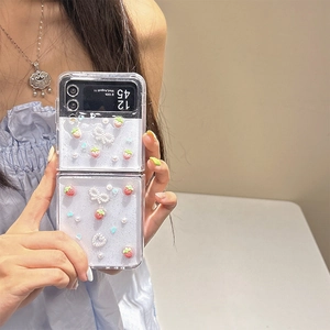 Detail of clear Samsung Z Flip6 case with 3D resin strawberries and pearl bow decoration