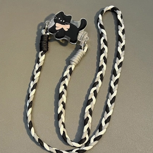 Close-up of hand-woven black and white lanyard with a cute cartoon cat acrylic clip