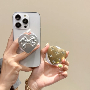 Detail showing heart-shaped phone grips with silver bow relief and gold star rhinestones