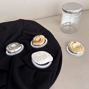 Macro detail of liquid metal style phone grip sockets in gold and silver chrome finishes