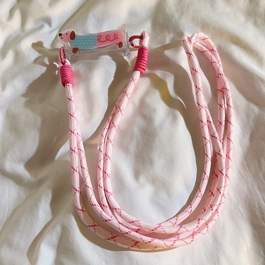 Pink braided crossbody phone strap featuring a cute dachshund acrylic clip and red diamond patterns