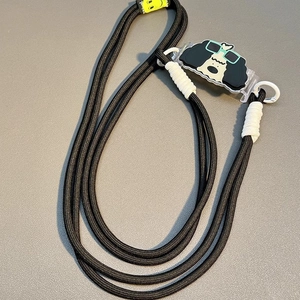 Detail of a thick black braided phone lanyard with a cartoon dog charm and white accents