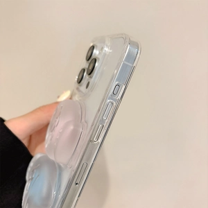 Detail view of transparent iPhone case showing precise side buttons and 3D bear ornament