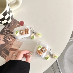 Détail de coque AirPods transparente avec breloques réalistes de cacahuètes et pistaches