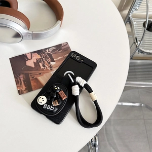 Détail d'une coque en cuir litchi avec miroir, pendentif ours et cordon tressé pratique