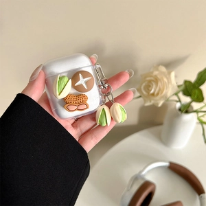 Détail des pendentifs 3D cacahuète et pistache sur une coque Airpods transparente