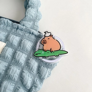 Detail van de schattige acryl telefoonhouder met een capybara op een krokodil