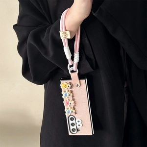 Cute pink leather flip phone case with 3D cartoon dog charms and a matching wrist lanyard strap