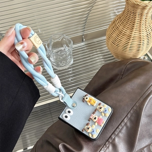 Detail view of the light blue leather phone case with cartoon dog and hand strap