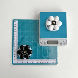 Detail showing weight and size of black and white flower magnetic phone grips with hearts