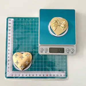 Detail view of heart-shaped gold metal accessories with bow and rhinestones on a scale