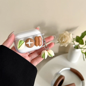 Détail de la coque AirPods avec charmes 3D pistache et cacahuète et pendentif assorti