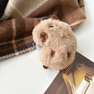 Gros plan d'un clip de téléphone capybara en peluche avec fourrure douce et broderies