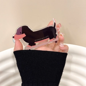 Detail of dachshund-shaped acrylic hair clip with colorful patterns and English lettering
