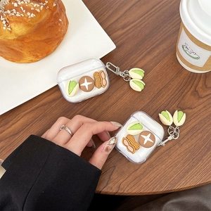 Étui AirPods transparent avec breloques 3D cacahuète et pistache sur table bois