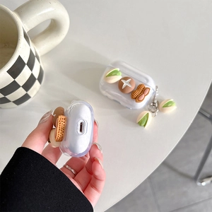 Vue détaillée de la coque AirPods Pro transparente avec breloques pistache et cacahuète