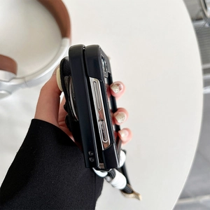 Gros plan sur la coque pliable noir mat avec boutons et dragonne tressée à la main