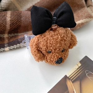 Gros plan détaillé d'une tête de caniche en peluche avec un nœud noir sur un clip réglable