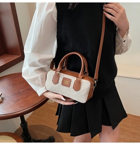 Detailed view of the mini canvas boston bag showing leather trim and branded logo tag