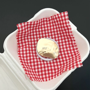 Detailed view of irregular golden metal accessory with happy script engraving