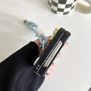 Side view of a black leather folding phone case with a blue wrist strap detail.