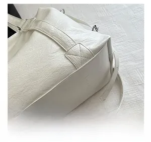 Detail showing cross-stitched reinforcement on white PU leather tote bag corners