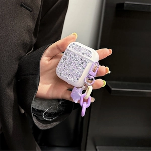 Close-up of purple glitter AirPods case with star pendant and acrylic chain decoration