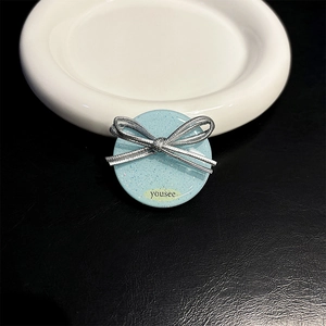 Detail of glitter light blue phone grip featuring silver bow and 'yousee' text detail