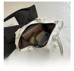 Spacious interior of white lychee leather tote bag showing items like umbrella and books