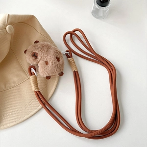Détail d'un pendentif capybara en peluche avec cordon tressé marron réglable pour téléphone