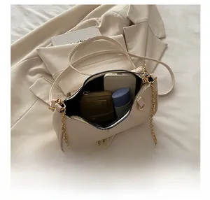 Internal view of cream baguette bag showing storage for phone, wallet and cosmetics