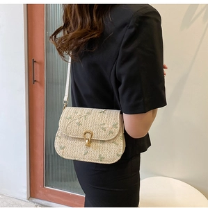 Détail du sac en paille tissée avec broderie florale et fermoir tournant en fer à cheval