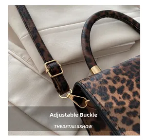 Detail of leopard print handbag showing the golden metal buckle and textured material