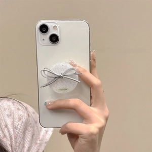 Detail of glitter resin phone grip with silver ribbon bow on a white smartphone
