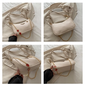 Detail shots of off-white lychee leather bag with golden strawberry chain and strap