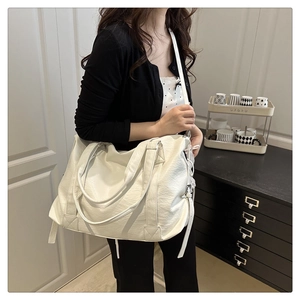 Detailed shot of white tote bag with lychee texture and adjustable shoulder straps