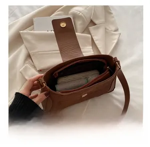 Interior capacity display of brown vintage crossbody bag with compartments and soft suede