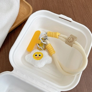 Détail d'une dragonne de téléphone en peluche œuf au plat avec cordon tressé épais crème.