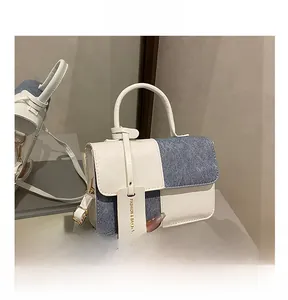 Detail of contrast color crossbody bag in white leather and blue denim patchwork