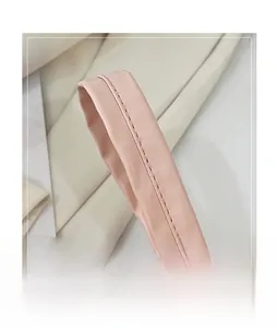 Détail de la poignée rose du sac à main avec couture précise et texture simili cuir