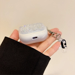 Close-up of AirPods case with glitter lid, metallic hook, and chunky decorative chain