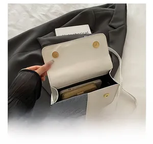Detail showing spacious interior of the colorblock crossbody bag with phone and wallet