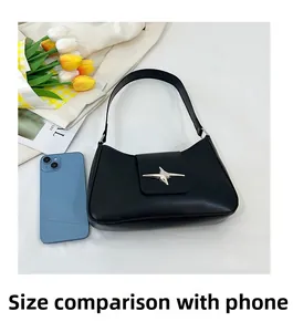 Comparaison de taille d'un sac baguette en cuir noir avec un smartphone bleu